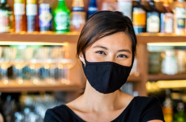 Credit card processing technologies help businesses during Covid - woman wearing mask accepting credit card