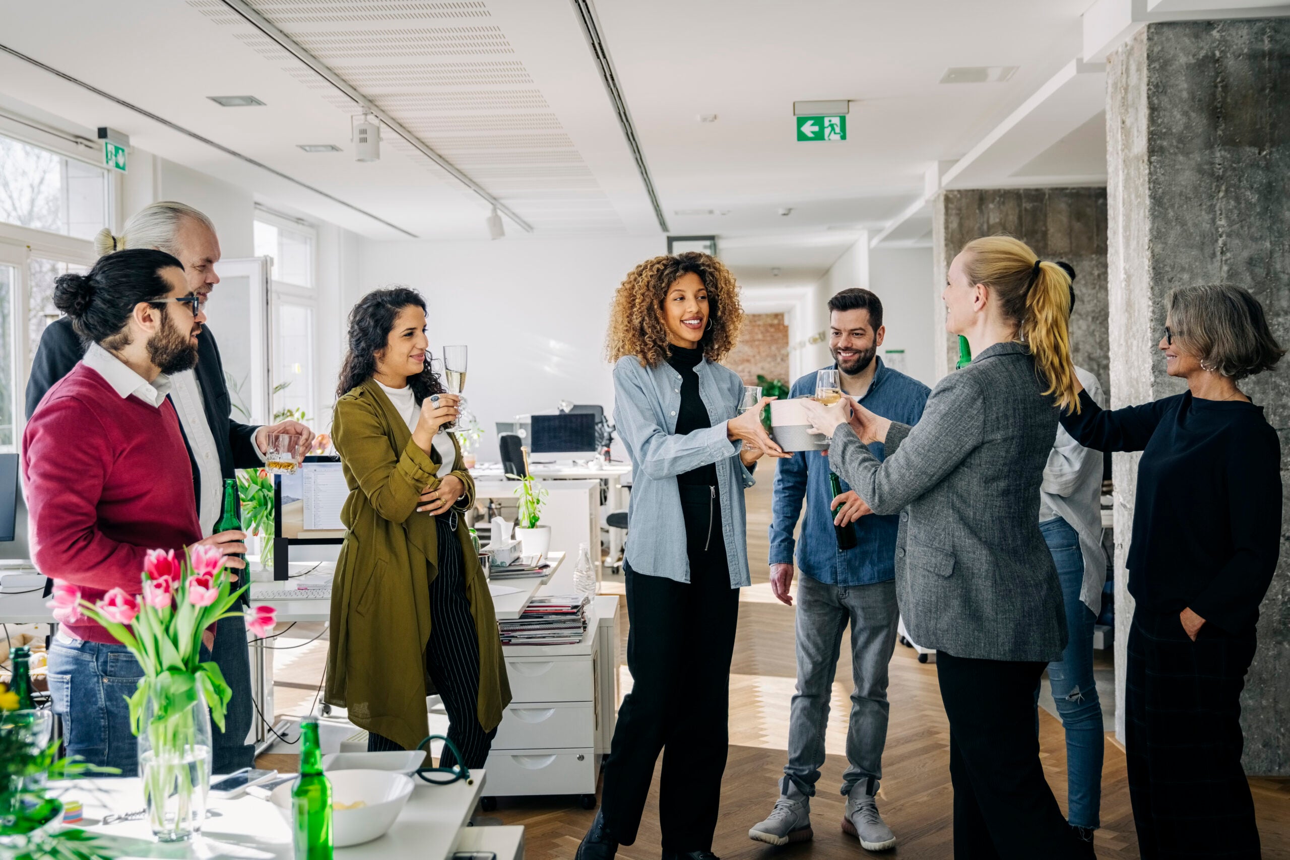 woman getting an employee bonus with co-workers looking on and celebrating