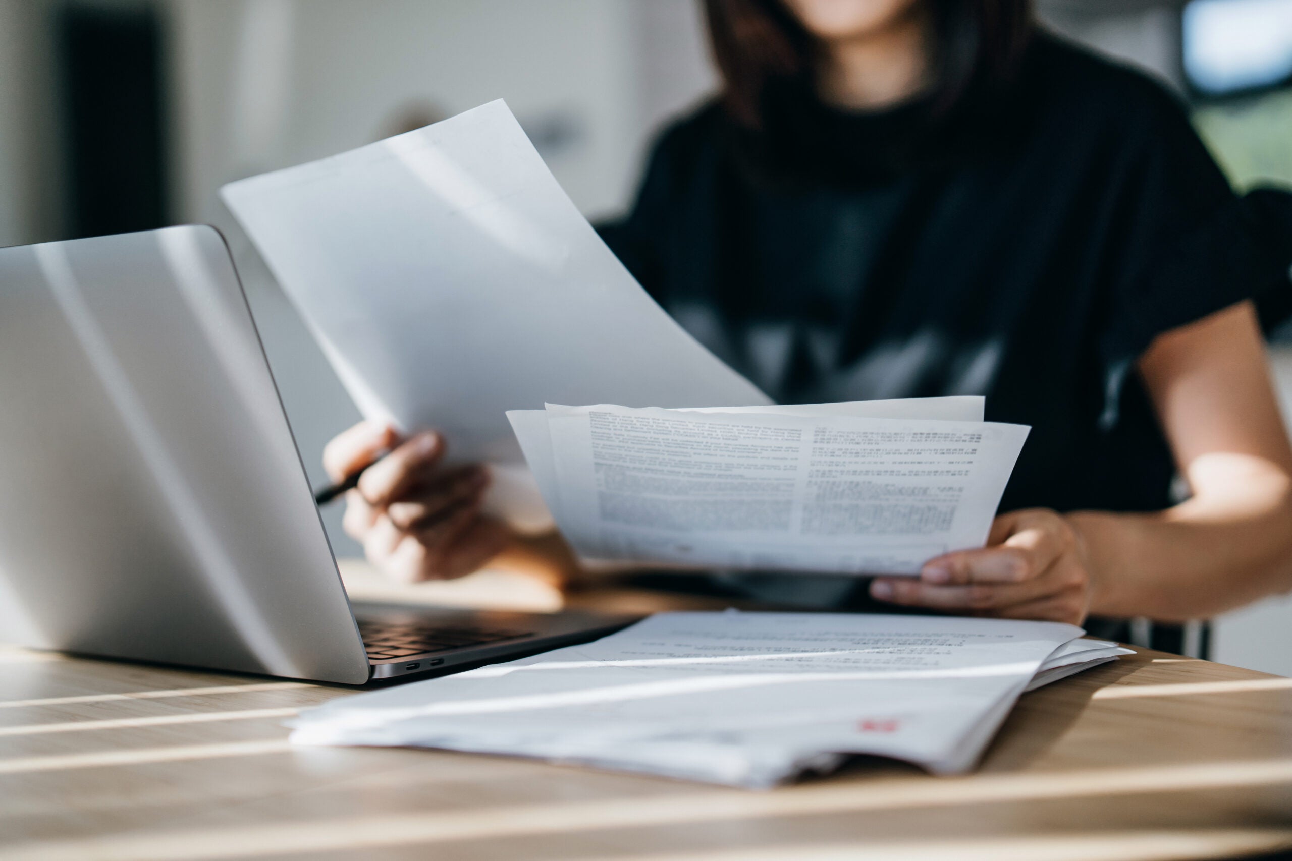 Cropped shot of young Asian woman handling personal banking and finance with laptop at home. Planning budget and calculating expenses. Managing taxes and financial bills. Wealth management. Digital banking habits. Smart banking with technology