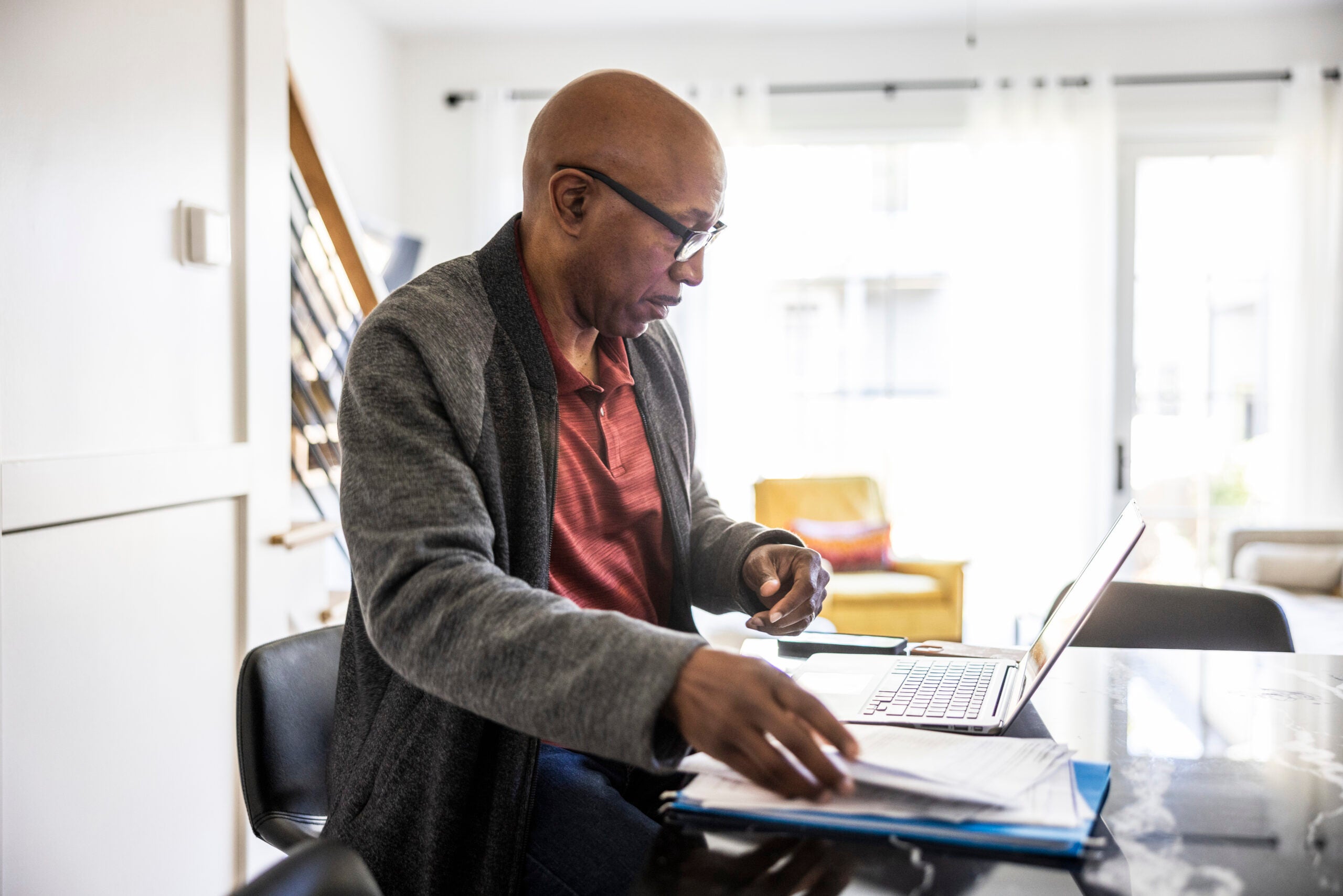 Senior man using laptop and researching at home